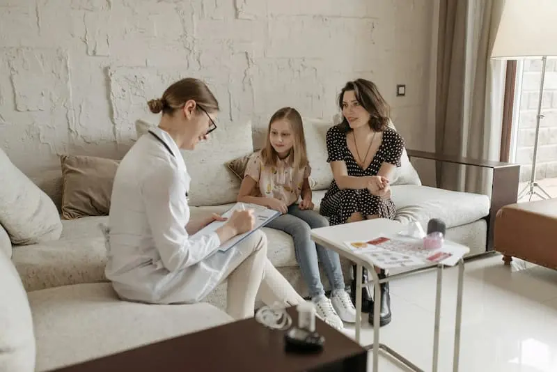 Mother and child speaking with a psychologist during a supportive consultation